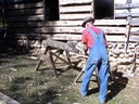 craftsman using a broad ax to hand hewn logs